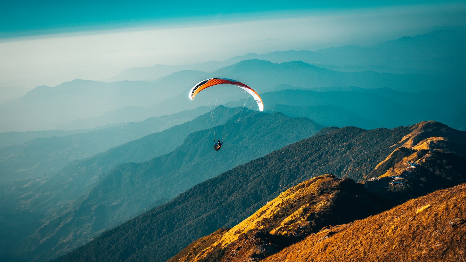 Parapente au-dessus d’une vallée verte